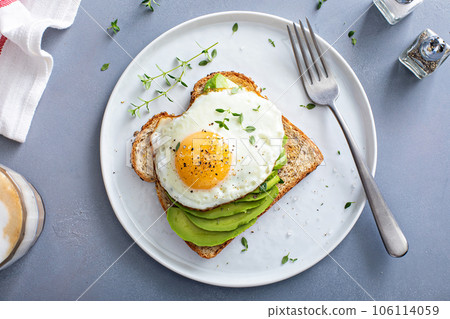 Avocado toast on a toasted multigrain bread with a fried egg 106114059