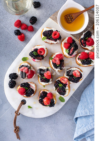 Berry and goat cheese bruschetta with mint and honey 106114087