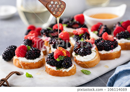 Berry and goat cheese bruschetta with mint and honey 106114089