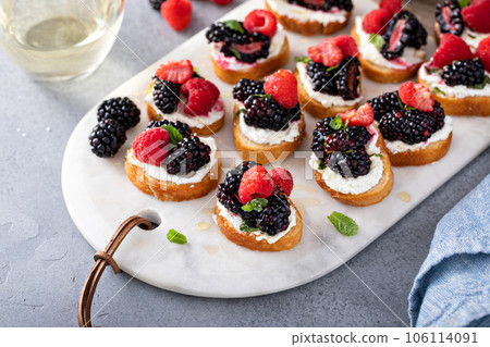 Berry and goat cheese bruschetta with mint and honey Berry and goat cheese bruschetta with mint and honey 106114091