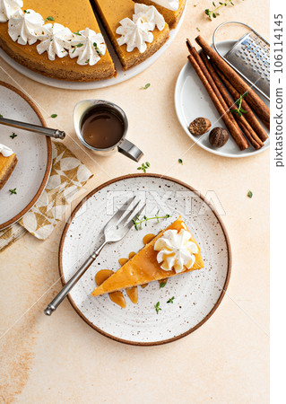 Pumpkin cheesecake with fall spices topped with whipped cream 106114145