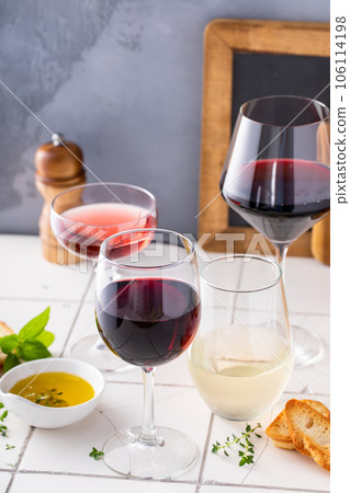 Variety of wine glasses with red, white and rose wine 106114198