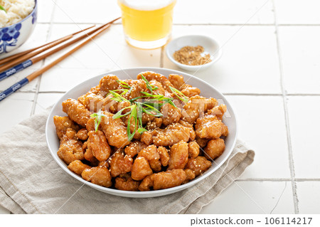 Orange chicken with green onions and sesame seeds 106114217