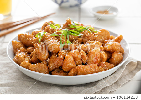 Orange chicken with green onions and sesame seeds 106114218