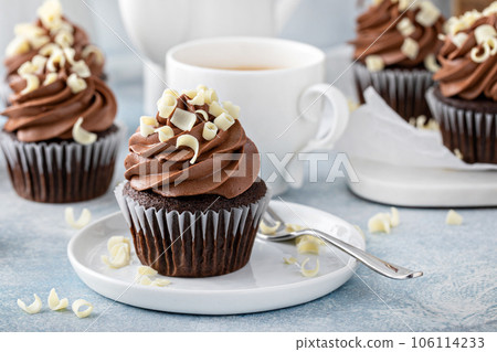 Dark chocolate cupcakes with whipped ganache frosting and white chocolate curls 106114233