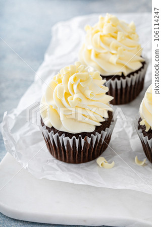 Chocolate cupcakes topped with cream cheese frosting 106114247