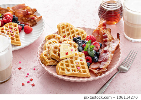 Valentines day breakfast with heart shaped waffles, bacon and berries Valentines day breakfast with heart shaped waffles, bacon and berries 106114270