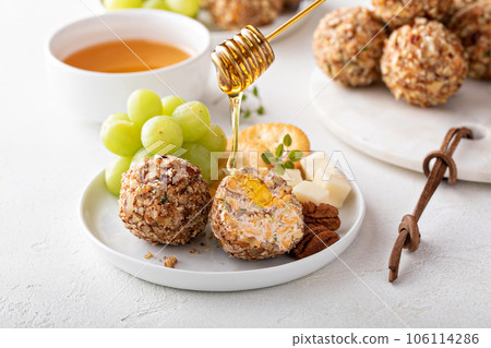 Cheese balls or truffles on a cheese board with crackers Cheese balls or truffles on a cheese board with crackers 106114286