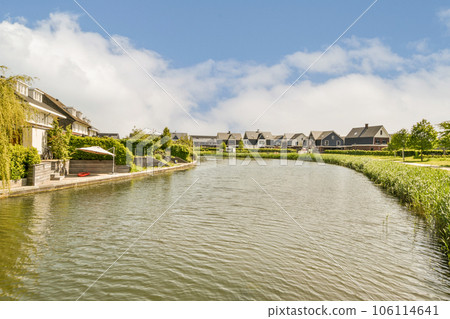 a river with houses and trees in the background on a sunny day, as seen from the water's edge a river with houses and trees in the background on a sunny day, as seen from the water's edge 106114641