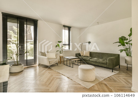 a living room with wood flooring and black shutters on the sliding glass door that leads to an outside patio a living room with wood flooring and black shutters on the sliding glass door that leads to an outside patio 106114649