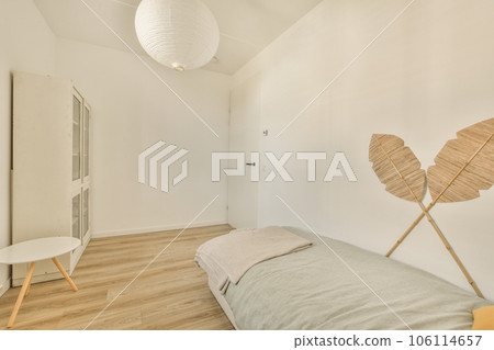 a bedroom with white walls and wood flooring on the wall, there is a bed in front of it a bedroom with white walls and wood flooring on the wall, there is a bed in front of it 106114657