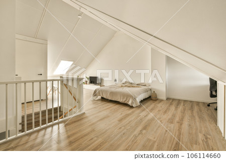 a bedroom with wood flooring and white walls in an attic - style home, showing the staircase leading up to the second floor a bedroom with wood flooring and white walls in an attic - style home, showing the staircase leading up to the second floor 106114660