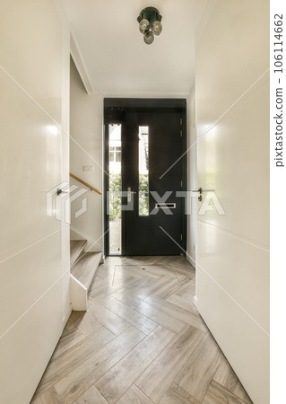 an entry way with wood flooring and black front door leading to the entranceway on the left is a white wall 106114662