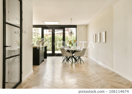 a dining room with wood flooring and black glass doors leading to the kitchen area in this home, there is an entrance way a dining room with wood flooring and black glass doors leading to the kitchen area in this home, there is an entrance way 106114674