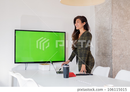Happy ethnic lady standing near monitor with chromakey in office Happy ethnic lady standing near monitor with chromakey in office 106115015