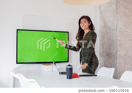 Delighted female demonstrating empty screen in meeting room 106115016