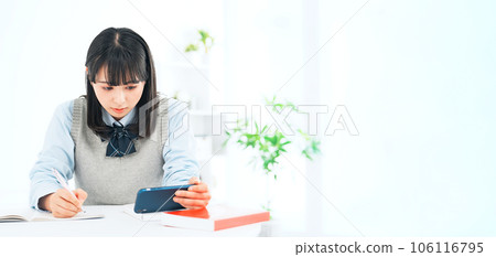 一邊看智能手機一邊學習的女學生 一邊看智能手機一邊學習的女學生 106116795