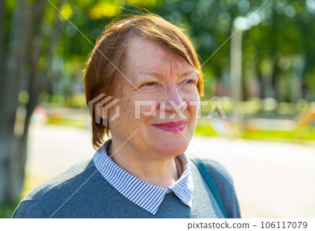 Smiling mature lady in urban park 106117079