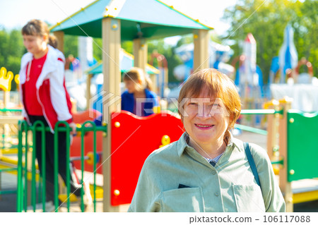 Grandmother walks with her grandchildren on playground 106117088