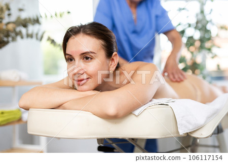 Young woman enjoying relaxing massage from professional female masseur Young woman enjoying relaxing massage from professional female masseur 106117154