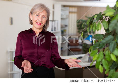 Portrait of positive elderly business woman in office 106117172