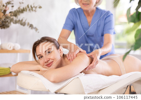 Young woman enjoying relaxing massage from professional female masseur Young woman enjoying relaxing massage from professional female masseur 106117445