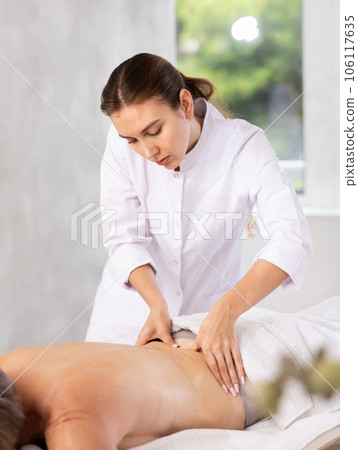 Young woman doing back massage to elderly woman Young woman doing back massage to elderly woman 106117635