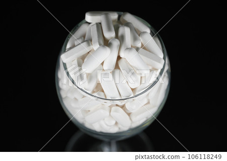 Supplement white tablet black background Supplement white tablet black background 106118249