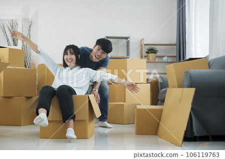 Happy couple is having fun with cardboard boxes in new house at moving day. Happy couple is having fun with cardboard boxes in new house at moving day. 106119763