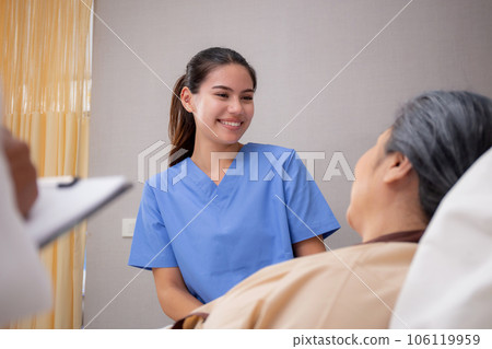 Young caregiver or nurse care and talking patient elderly on bed for consoling in room at hospital. Young caregiver or nurse care and talking patient elderly on bed for consoling in room at hospital. 106119959