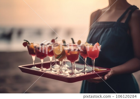 waiter girl holding cocktails and soft drinks on a tray  106120284