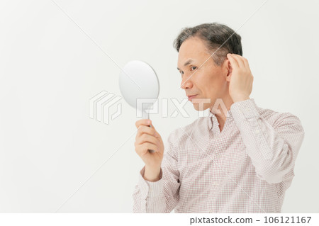 A man who cares about his hair while looking in the mirror A man who cares about his hair while looking in the mirror 106121167
