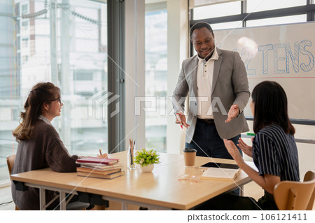 An African American male teacher teaching English for Asian students at a language school. 106121411