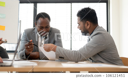 A professional African-American businessman is having a meeting with an Asian financial consultant 106121451