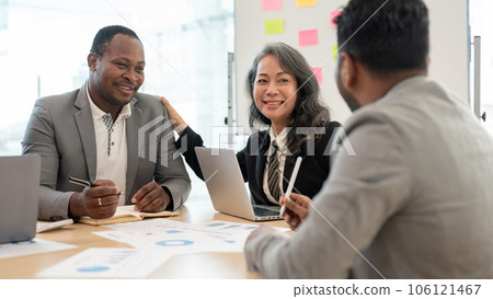 A happy senior Asian businesswoman is in a meeting with African American businessmen. 106121467