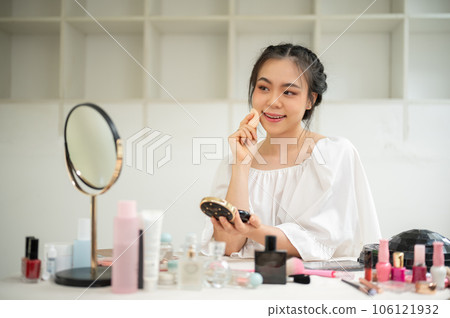 A beautiful Asian woman applies cushion or press powder on her face. Lifestyle concept 106121932