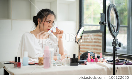 An attractive Asian female makeup artist curling the eyelashes 106122060