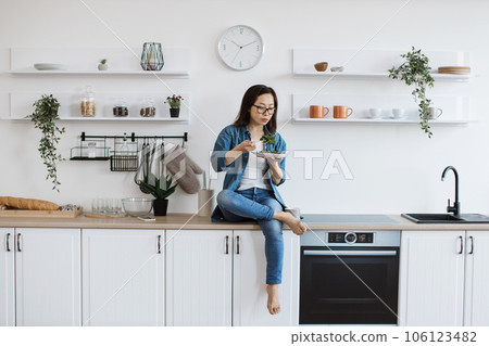 Female cook tasting vegetarian meal in kitchen interior Female cook tasting vegetarian meal in kitchen interior 106123482