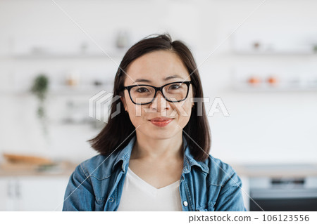 Asian woman in glasses posing at home in kitchen interior Asian woman in glasses posing at home in kitchen interior 106123556