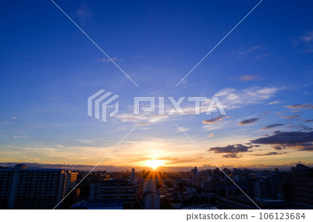 Dawn in the city. The eastern sky brightens and the sun before the clouds rise shows a beautiful gradation. Kobe city Dawn in the city. The eastern sky brightens and the sun before the clouds rise shows a beautiful gradation. Kobe city 106123684