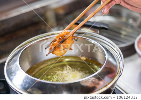 將炸柿子放入天婦羅鍋中煎炸 106124312