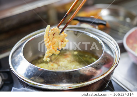 將炸柿子放入天婦羅鍋中煎炸 106124314