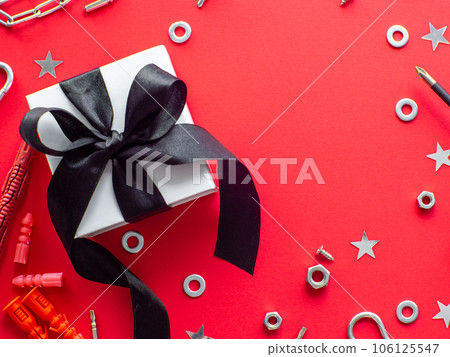 Construction tools and wrapped gift on red background Construction tools and wrapped gift on red background 106125547