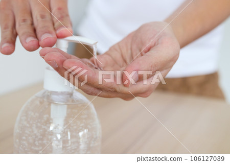 Woman using alcohol sanitizer gel rub for cleaning hand COVID-19 corona virus prevention concept 106127089