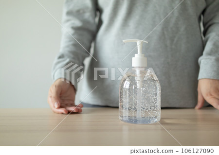 Woman using alcohol sanitizer gel rub for cleaning hand COVID-19 corona virus prevention concept 106127090