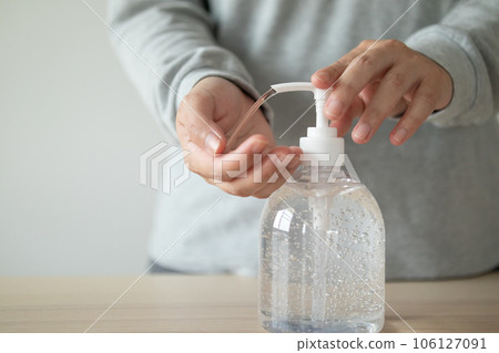 Woman using alcohol sanitizer gel rub for cleaning hand COVID-19 corona virus prevention concept 106127091