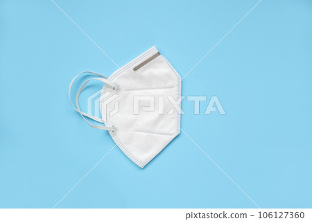 KN95 face mask on blue background protection against pm 2.5 polution and COVID-19 coronavirus. Healthcare and medical concept KN95 face mask on blue background protection against pm 2.5 polution and COVID-19 coronavirus. Healthcare and medical concept 106127360