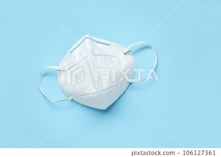 KN95 face mask on blue background protection against pm 2.5 polution and COVID-19 coronavirus. Healthcare and medical concept 106127361