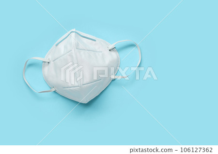 KN95 face mask on blue background protection against pm 2.5 polution and COVID-19 coronavirus. Healthcare and medical concept 106127362