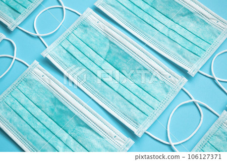 Surgical face mask on blue background protection against COVID-19 coronavirus. Healthcare and medical concept Surgical face mask on blue background protection against COVID-19 coronavirus. Healthcare and medical concept 106127371